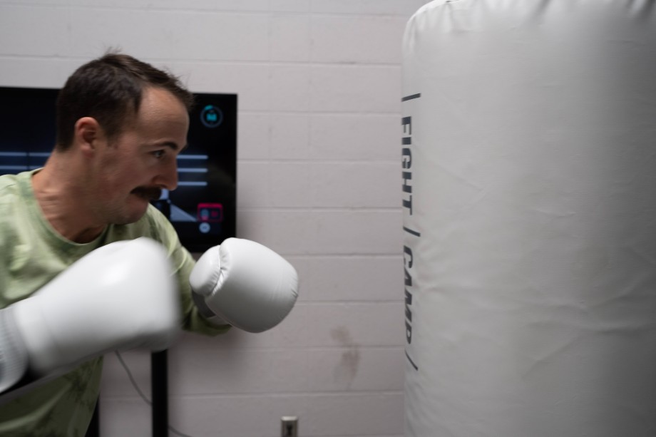 Coop with a FightCamp punching bag and boxing gloves.