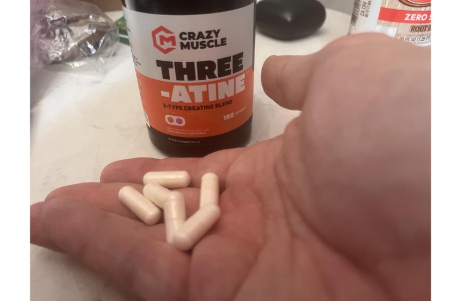 man holding crazy muscle three-atine capsules