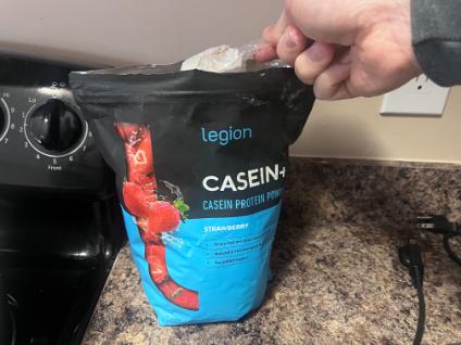 man scooping legion strawberry casein