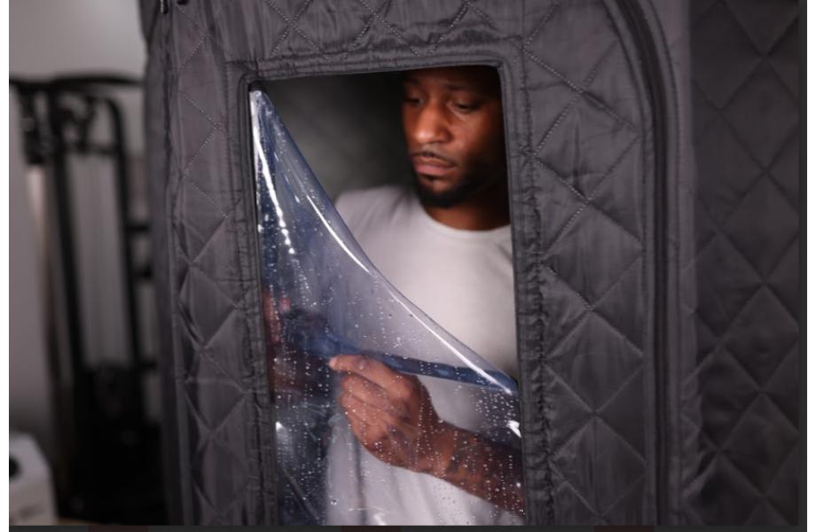 man using sauna box, zipping up the cover to keep the heat in 