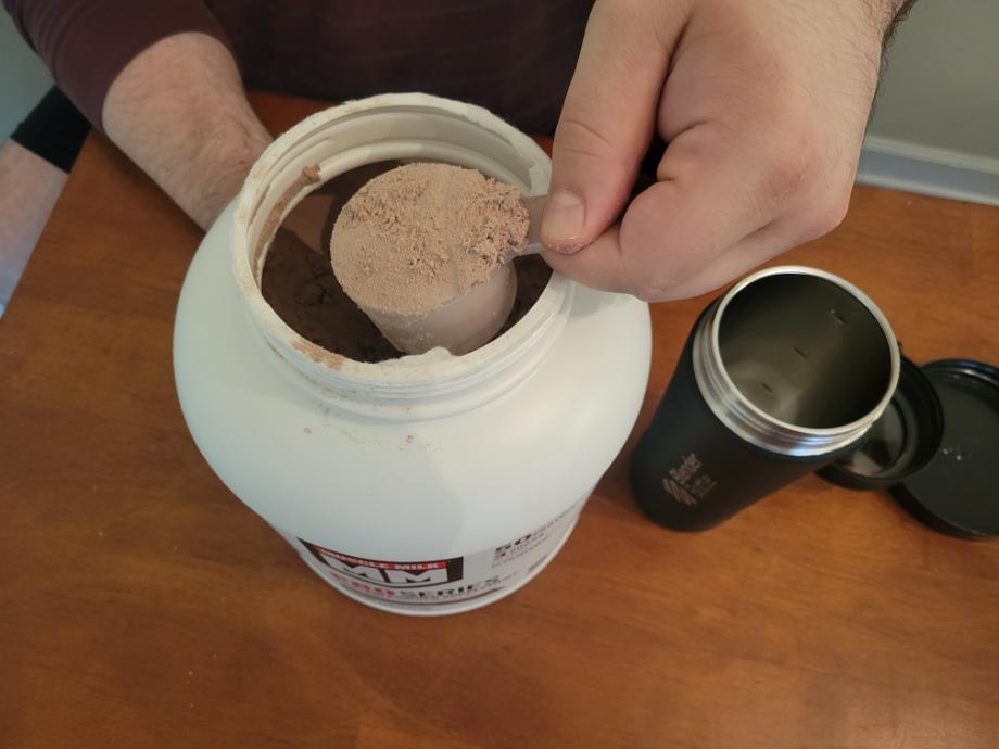 Scooping Muscle Milk Pro Series into a shaker