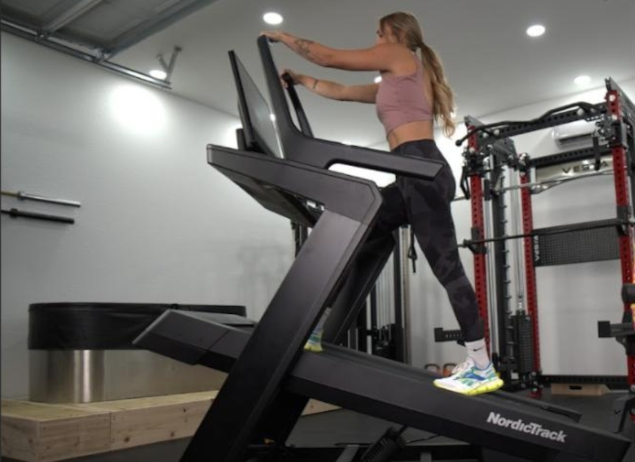 A woman walks at a steep incline on a Nordictrack X24 Treadmill