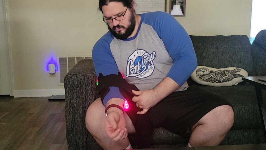 Man adjusting the NovaaLab Deep Healing Pad around his elbow