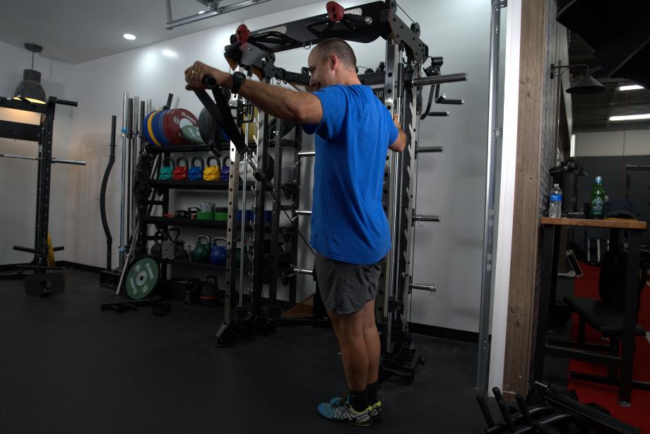 Man performing one-arm raises on the BRUTEforce UX1 FUnctional Trainer