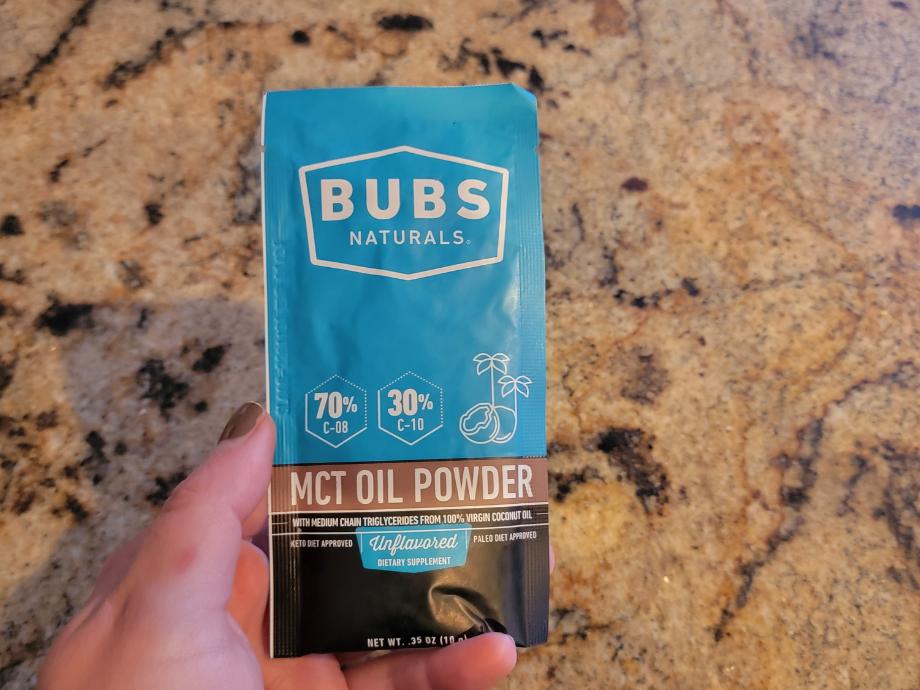 A person holds a packet of BUBS MCT Oil Powder