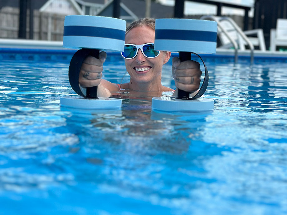 person-in-pool-with-water-dumbbells