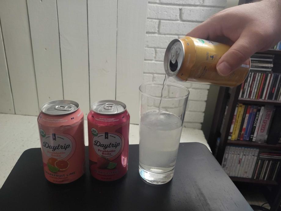 Person pouring Daytrip soda into a glass