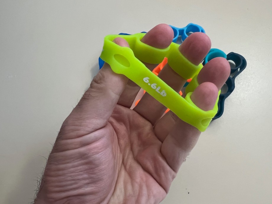 A PRNKSTR Hand Grip Strengthener on a person's hand