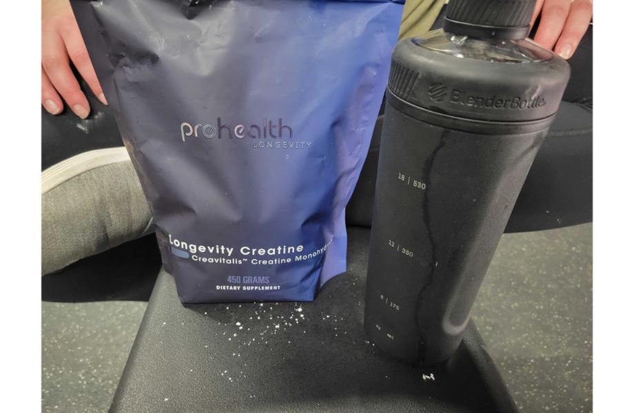 A purple bag of ProHealth Longevity creatine next to a black shaker cup 