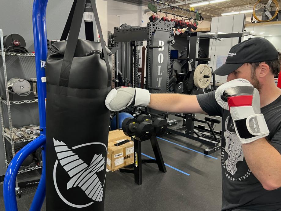 Man punching and punching bag with the Hayabusa T3 Boxing Gloves