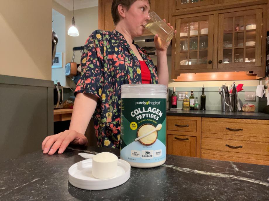 A woman drinks Purely Inspired Collagen Peptides from a glass.