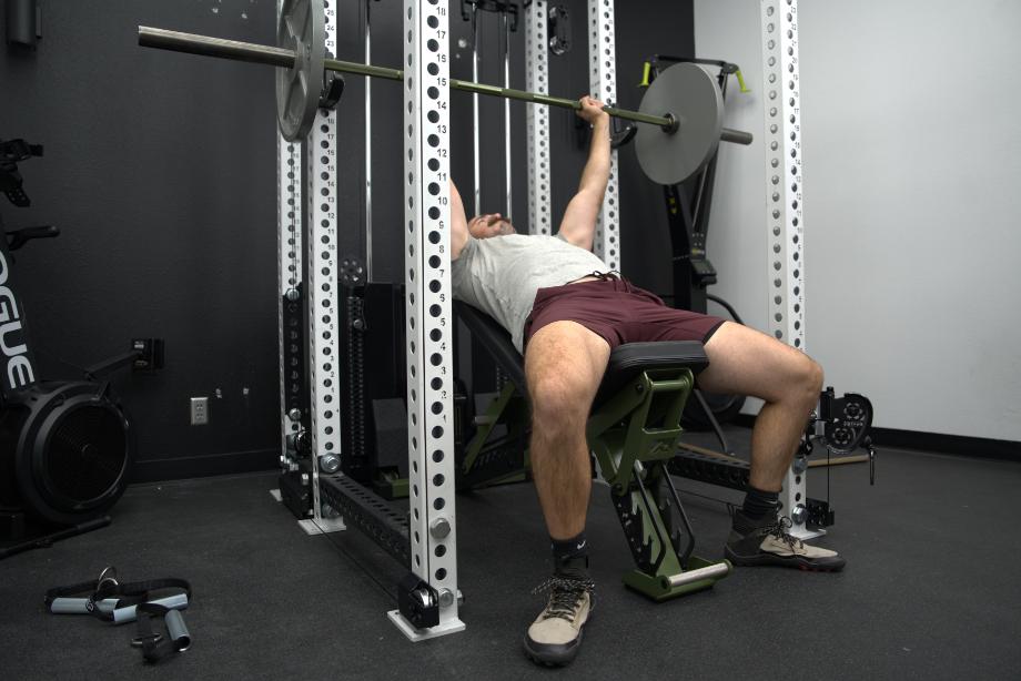 Man performing incline bench press within a REP power rack and Ares 2.0