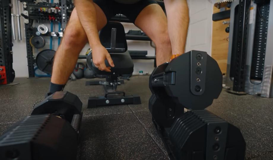 Man placing the REP x Pepin Fast Series dumbbells back onto the weight cradles