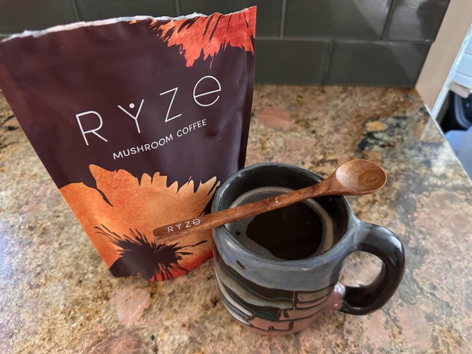 A beautiful cup of Ryze mushroom coffee next to the bag.