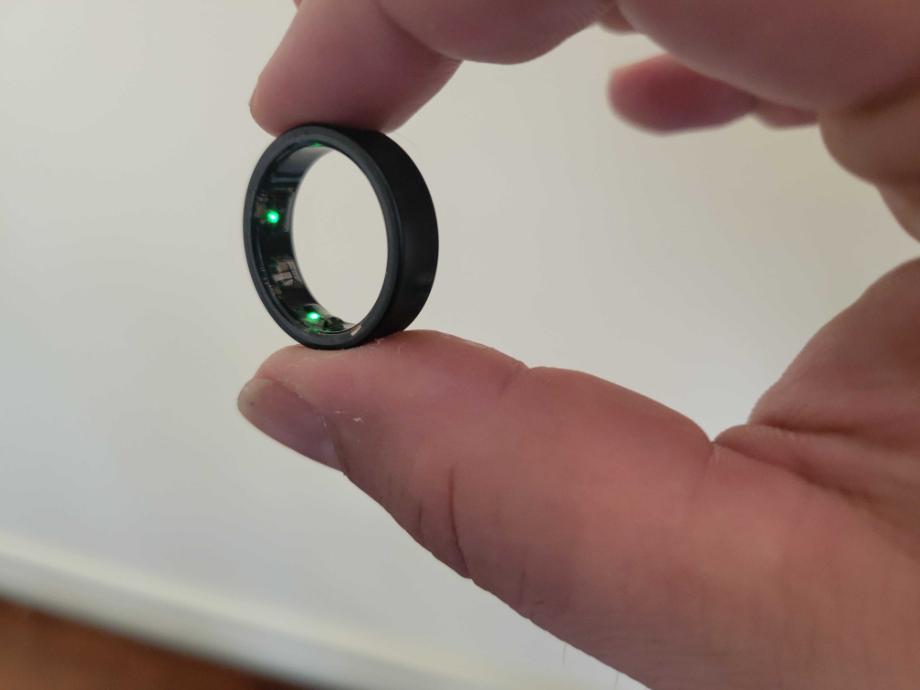 A Samsung Galaxy Ring is held to show the lights on the inside