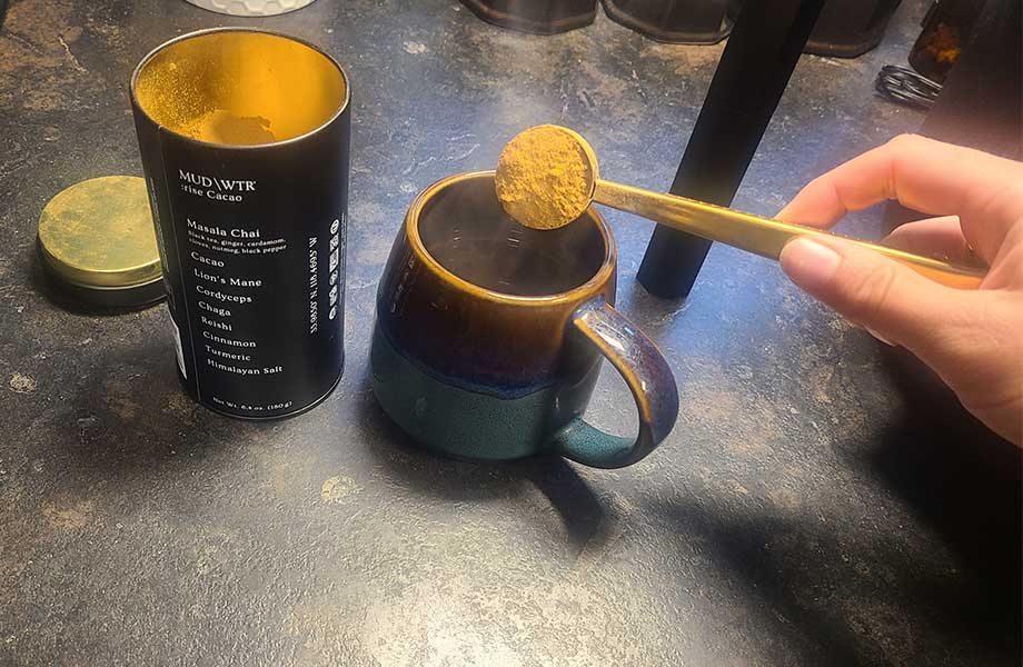 Scooping MUD\WTR into a mug