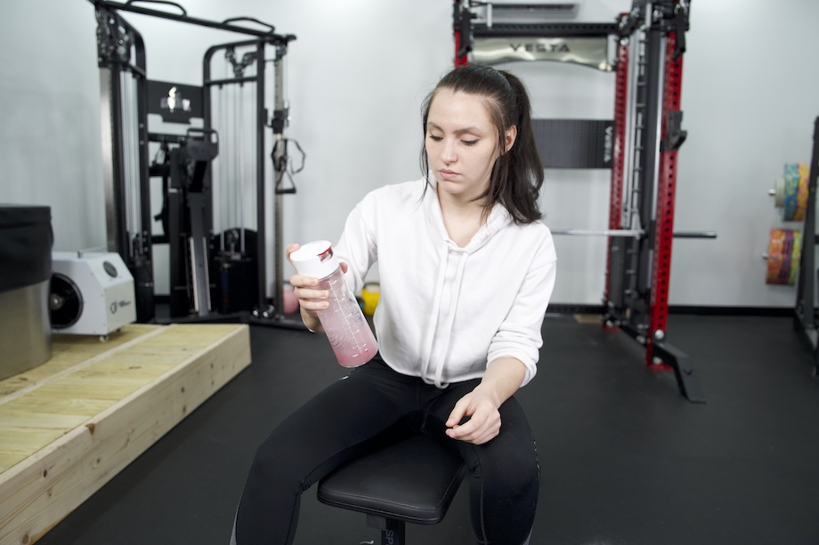 An image of a person shaking Sports Research Hydrate electrolytes in a shaker