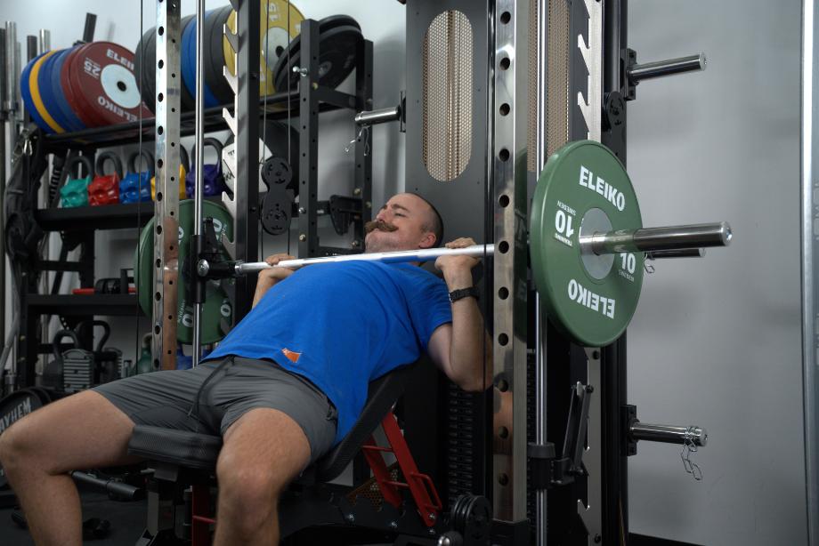 Man doing bench press on the Smith machine of the BRUTEforce UX1 Functional Trainer