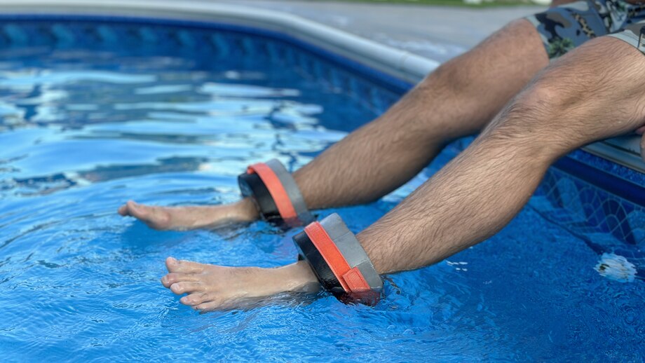 Our tester wears Sportneer Foam Aquatic Cuffs while dangling their feet in a pool