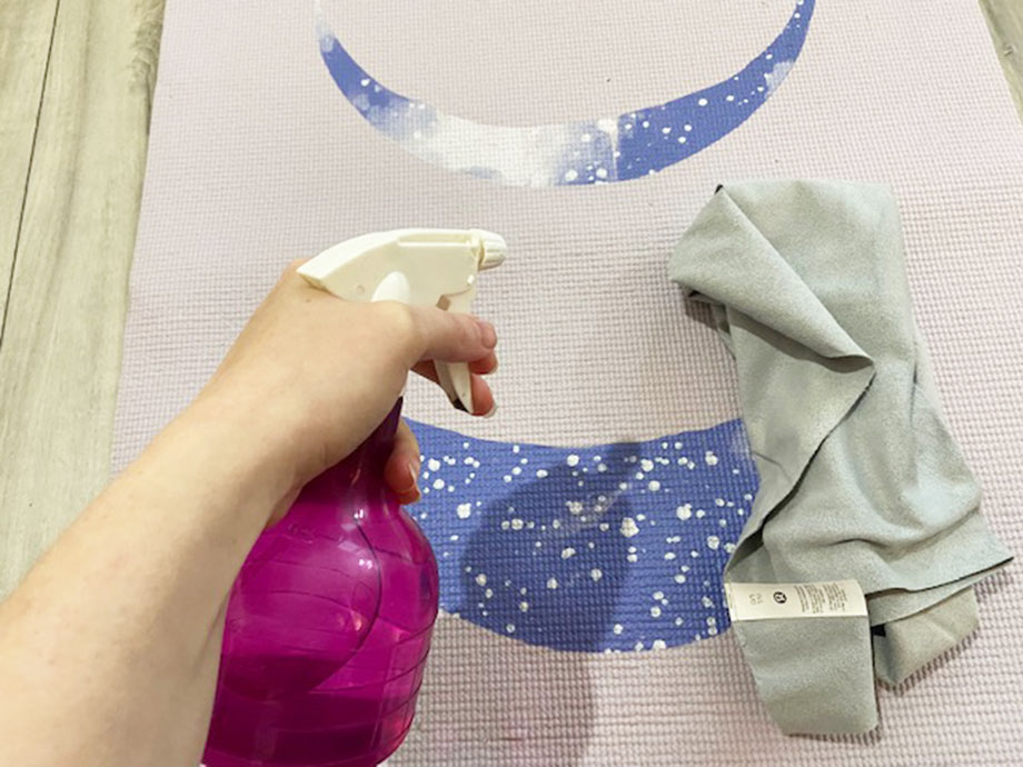 how to clean a yoga mat, spraying with homemade cleanser