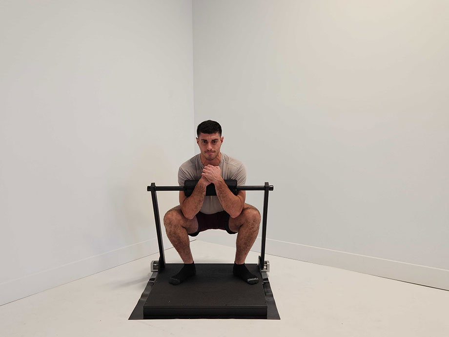 A man is shown squatting with the Isophit Trainer