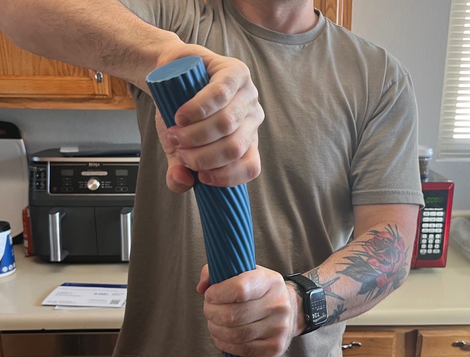 A person squeezing a Theraband FlexBar