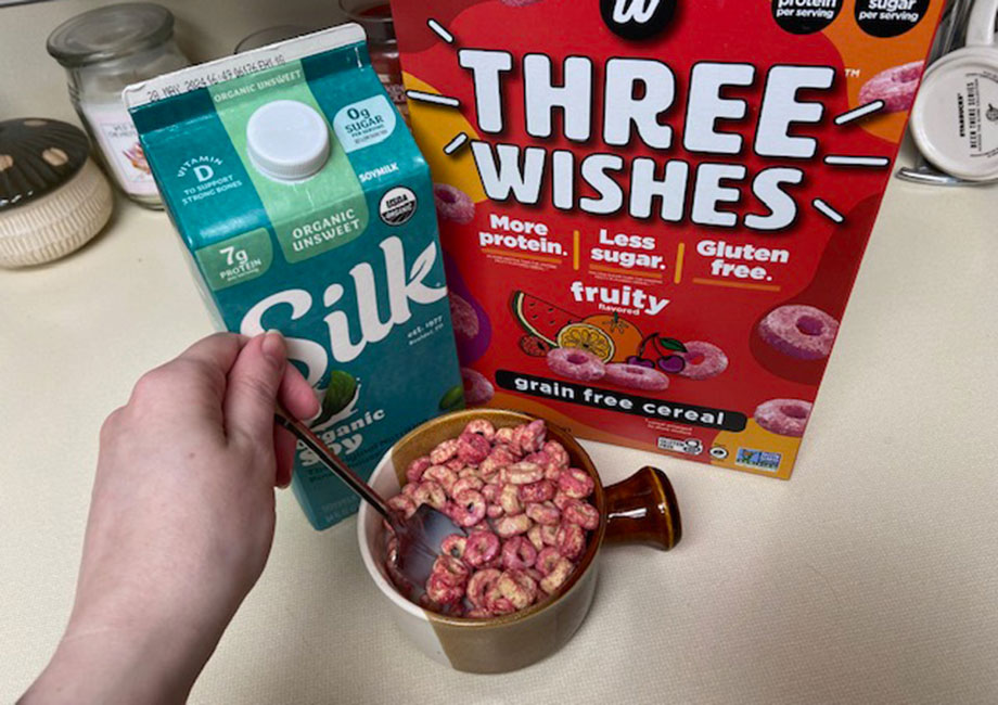 A person prepares a bowl of Three Wishes Protein Cereal.