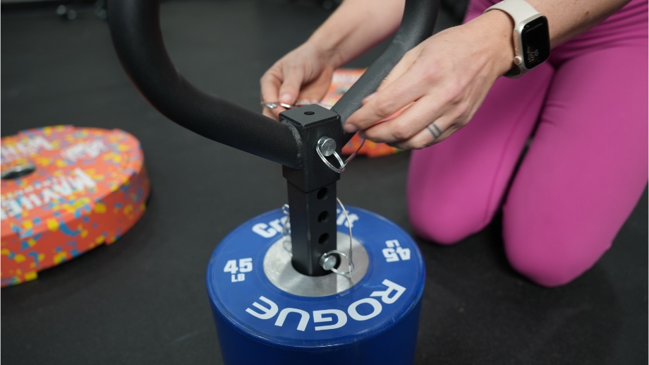 Lindsay fastens the pin in the handle of a Titan Fitness Plate Loadable Kettlebell Swing.