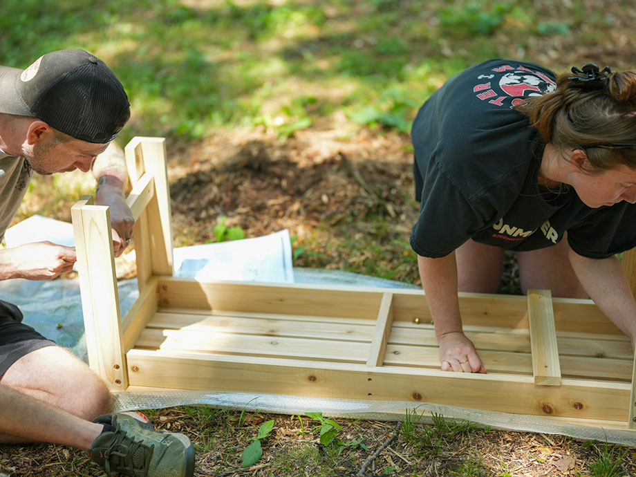 two-people-building-wooden-sauna-bench