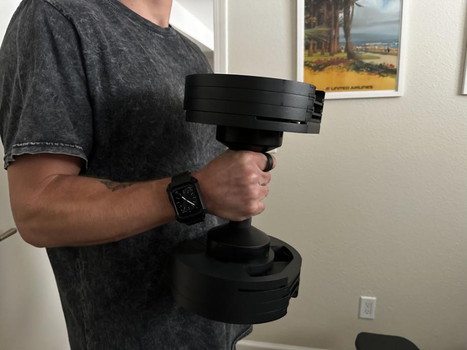 Our tester works out with an adjustable dumbbell while wearing the Ultrahuman Ring AIR.