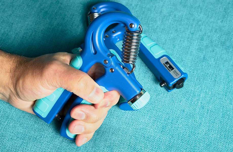 A close look at a hand using a grip strengthener tool.