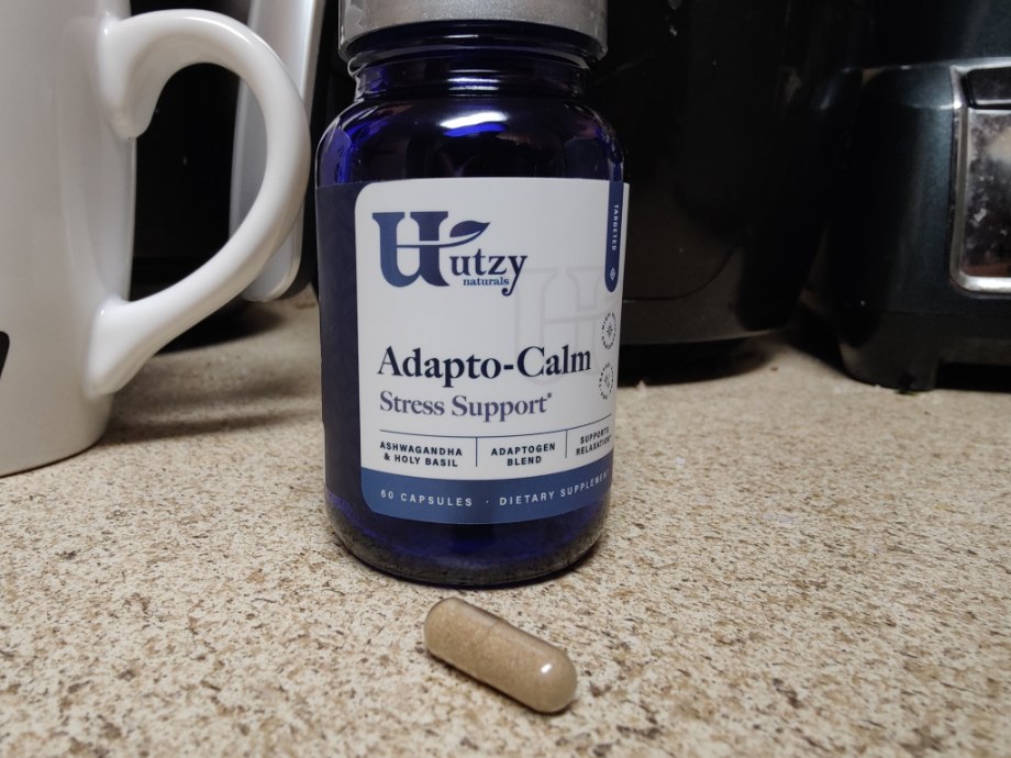 Bottle of Utzy Naturals Adapto-Calm with capsule in front of it