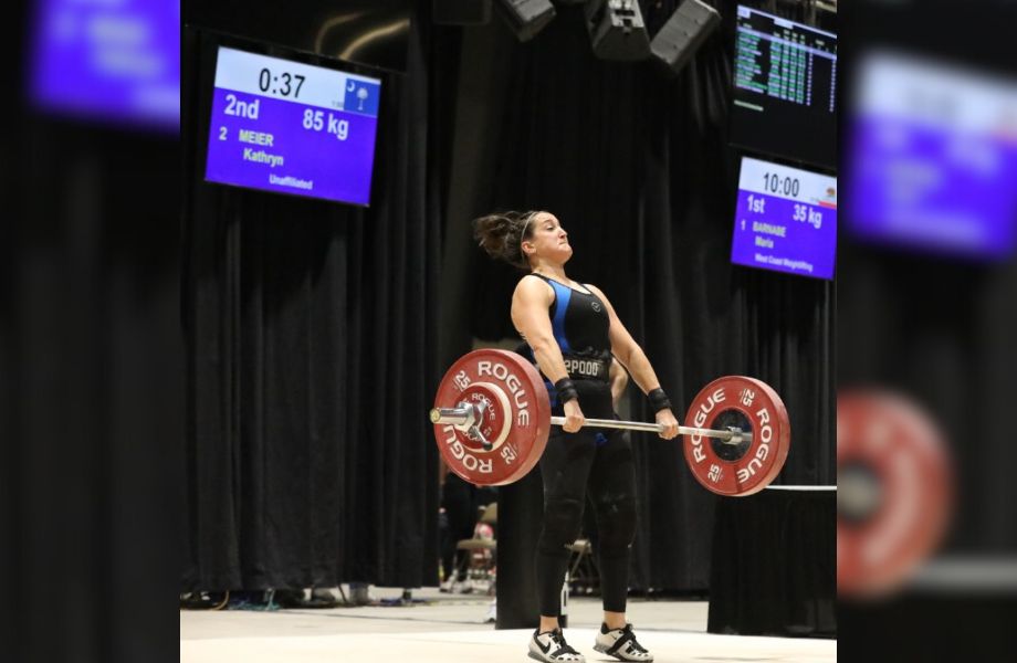 Woman lifting 85 kilograms in the clean and jerk during an Olympic weightlifting competition