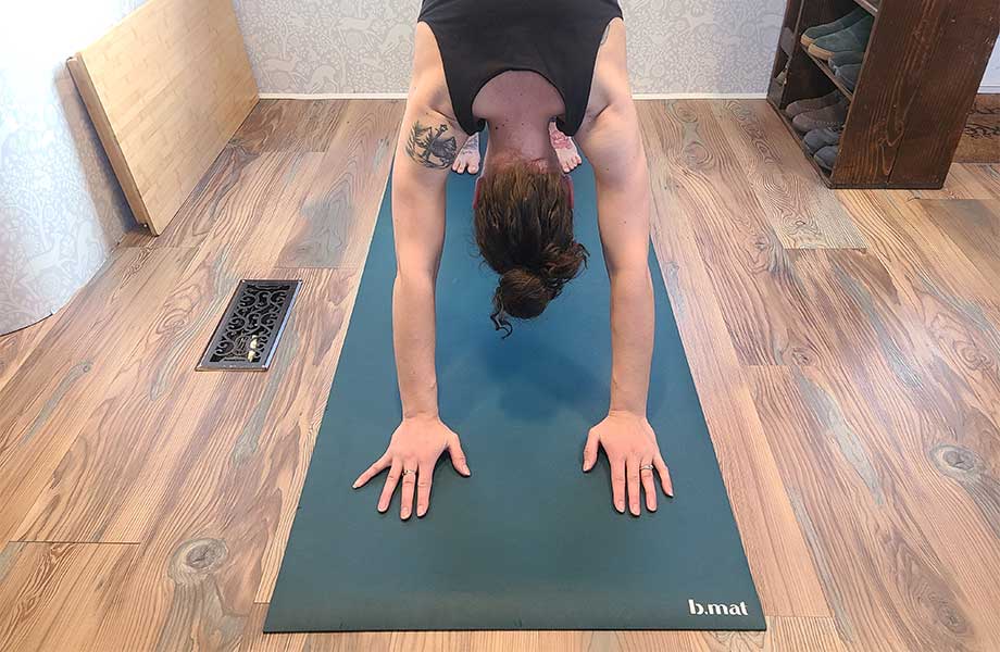 Woman doing down dog on a b, mat yoga mat