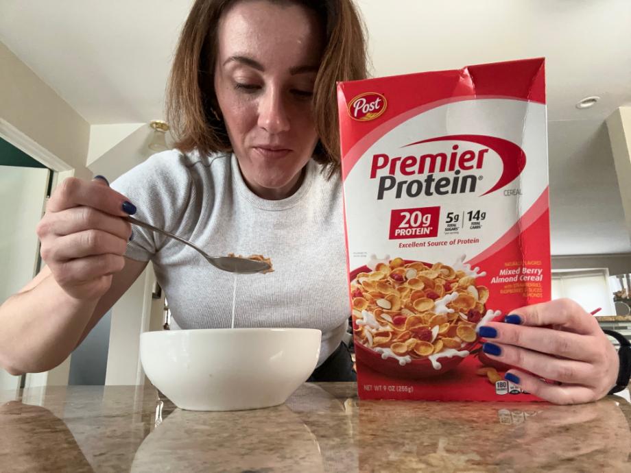 Woman eating Premier Protein Cereal.