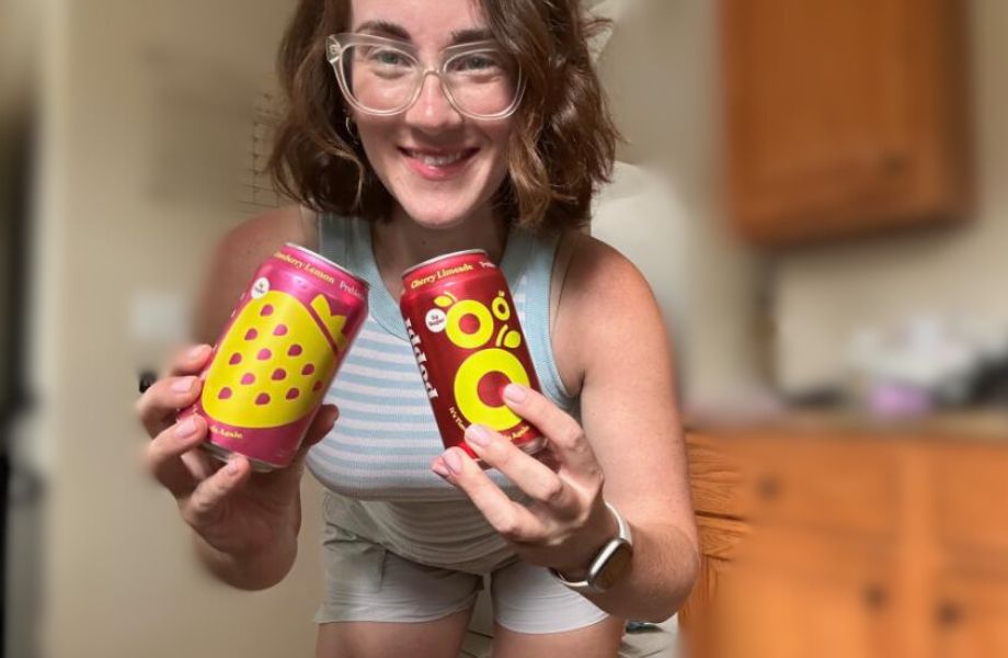 A woman holding two cans of poppi prebiotic soda