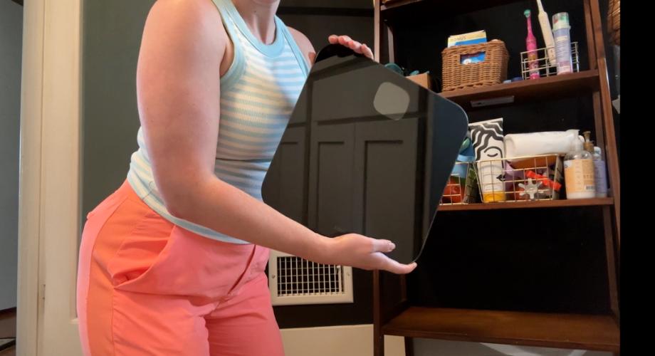 Woman holding Fitbit aria air smart scale