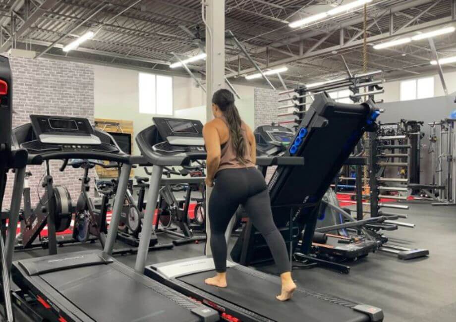 Woman running barefoot on a treadmill