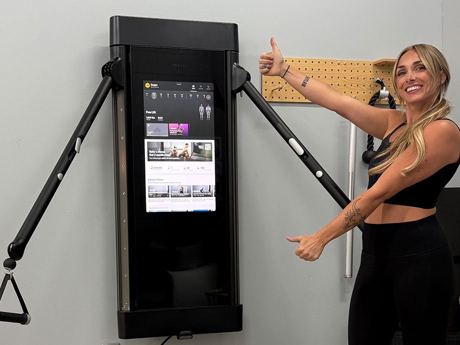 woman standing with the tonal smart home gym machine