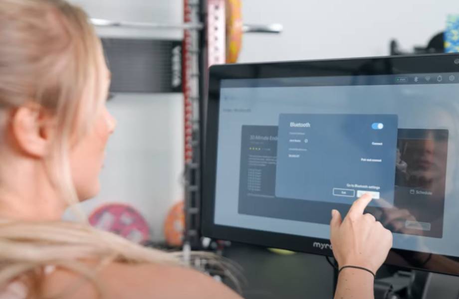 A woman using the myrow monitor to adjust her Bluetooth settings