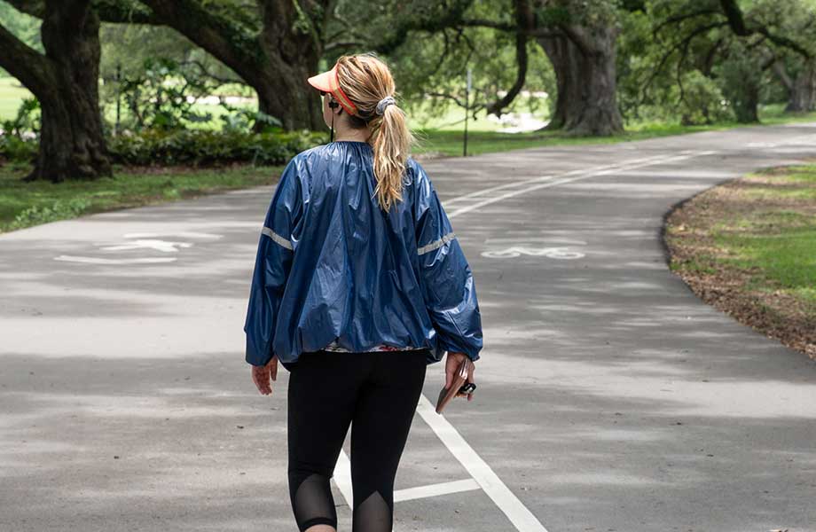 Closer view of a woman wearing a sauna suit jacket while walking outside