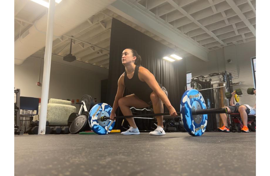 woman using synergee games barbell snatch