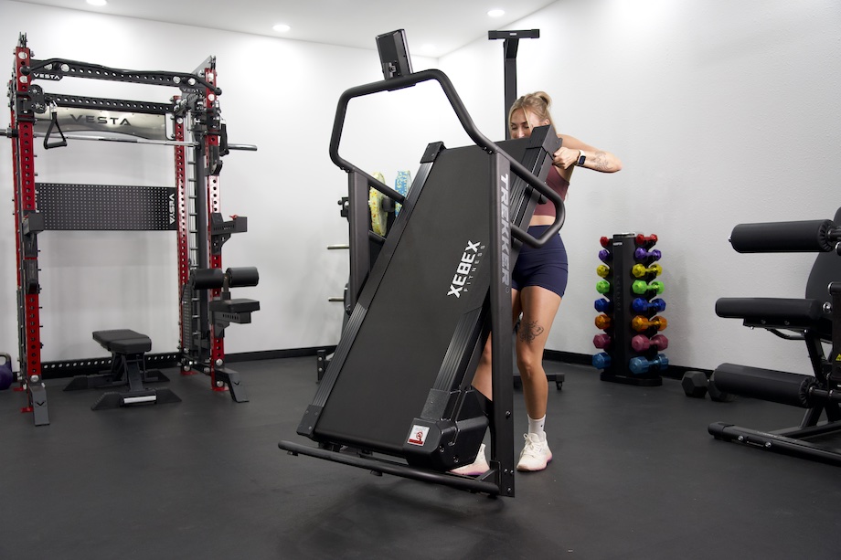 Lindsay Scheele, CPT folds up a Xebex Trekker 4000 treadmill.